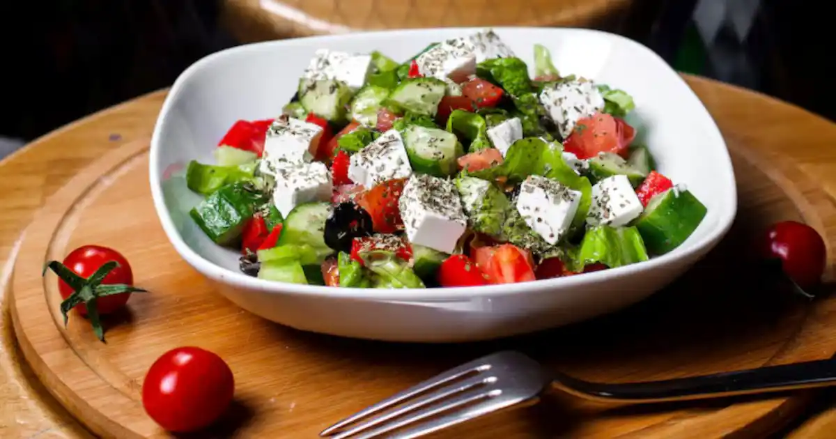 Mediterranean cucumber salad with colorful vegetables, fresh herbs, and a light vinaigrette, served under warm natural light.